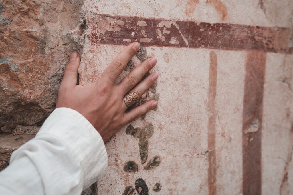 Closeup shot of a hand touching the historic ruins in the Ephesus Ancient City in Izmir, Turkey